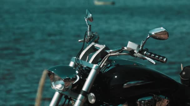 Bicicletta chopper nera in piedi sulla riva blu del lago — Video Stock