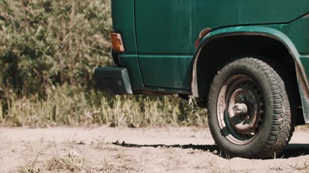 Onderdeel van groene minivan staande op onverharde weg op aard — Stockvideo