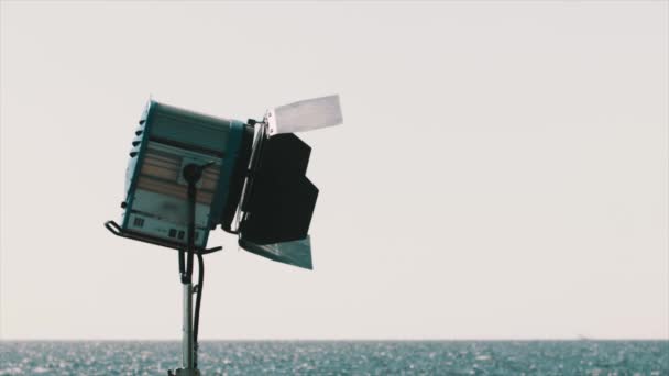 Haz de luz foco de película en frente del cielo en la orilla del mar — Vídeos de Stock