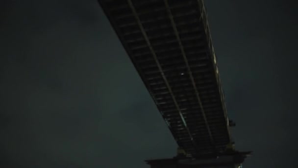 Вид снизу на мост с сухими ветвями деревьев в темную ночь — стоковое видео