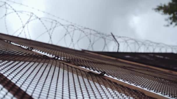 Metalowe ogrodzenia z drutu kolczastego, na górze przed szare niebo ogniwo łańcucha — Wideo stockowe
