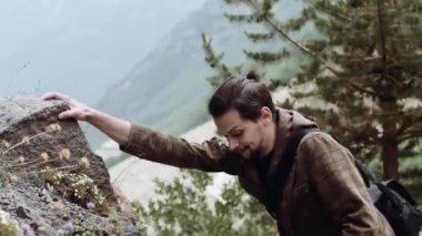 Genç sakallı adam climbes Mountain kayada görmek görüş iz