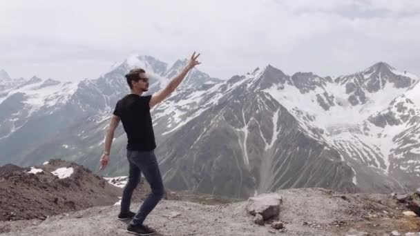 Vrolijke man in zwarte shirt en zonnebril juichen glimlachen bij mountain Zie zicht — Stockvideo