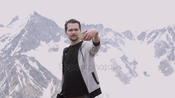 Joven con capucha rayada haciendo selfie en la montaña ver la vista — Vídeo de stock