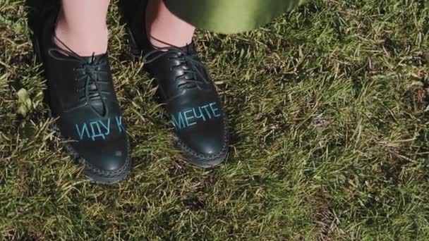 Girls feet in black leather boots with russian text "going toward dream" — Stock Video