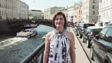 Eski şehir merkezi Nehri boyunca benekli elbiseli genç kadın şarkı söylüyor