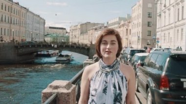 Eski şehir merkezi Nehri boyunca benekli elbiseli neşeli kız şarkı söylüyor