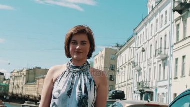 Eski şehirde setin kameraya bakarak benekli elbiseli neşeli kız