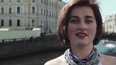 Benekli elbiseli neşeli kız portresi eski şehir merkezinde Nehri boyunca şarkı söylüyor