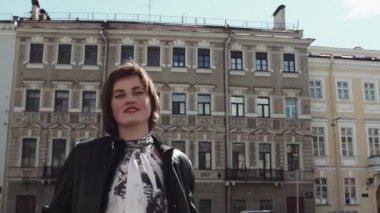 Siyah deri ceketli eski şehirde güzel şarkıcı kız gerçekleştirir