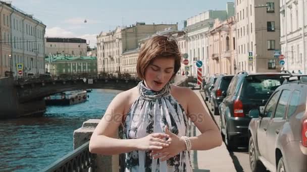 Chica alegre en vestido manchado canta en el terraplén en el centro de la ciudad vieja — Vídeo de stock