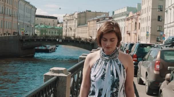 Весела молода жінка в плямистій сукні співає на набережній в старому центрі міста — стокове відео