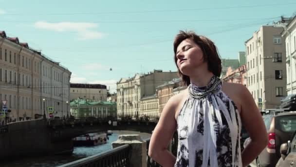 Bella donna in abito macchiato gode momento sul lungofiume nel centro storico della città — Video Stock