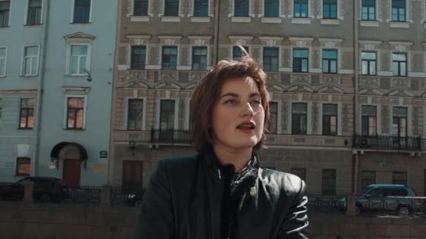 Wesoły wokalista dziewczyna wykonuje w starym mieście w czarną skórzaną kurtkę — Wideo stockowe