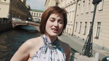 Eski şehir merkezi Nehri boyunca ışık elbiseli güzel kız şarkı söylüyor