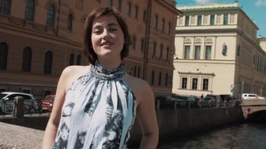 Eski şehir merkezi Nehri boyunca ışık elbiseli çekici kadın şarkı söylüyor