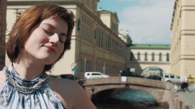 Eski şehir merkezi Nehri boyunca ışık elbiseli güzel kadın şarkı söylüyor