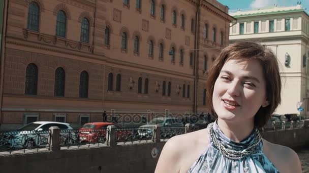 Gioiosa ragazza in abito leggero canta lungo il fiume nel centro storico della città — Video Stock