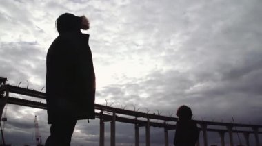 Karayolu Köprüsü ile nehir kıyısında duran iki insan siluetleri