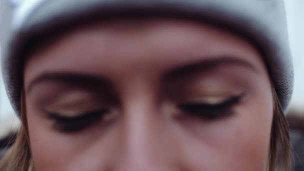 Jonge attracive vrouw in gebreide streetwear hoed opent ogen — Stockvideo