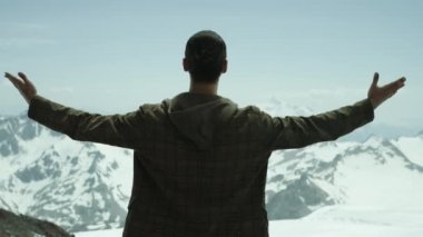 Genç adam yayılır arms karlı dağlar doğal manzaralı adlı sakallı