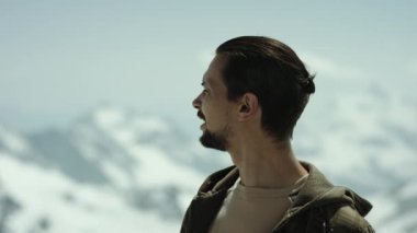 Genç adam dağın tepesinde doğal görünümü nefes derin ve etrafında görünüyor sakallı