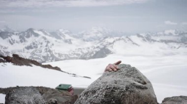 Genç adam dağcı karlı dağ manzaralı görünüm güneşli Rock'ta tırmanıyor