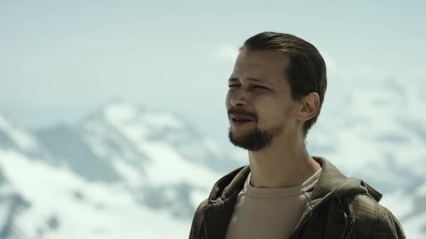 Giovane uomo barbuto all'apice della montagna con vista panoramica occhi strabici e parlando — Video Stock