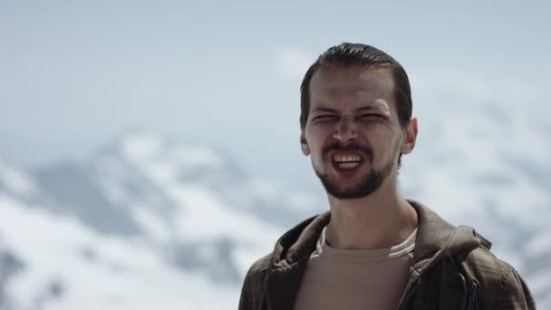 Hombre barbudo enojado en el pináculo de la montaña con vista panorámica entrecerrar los ojos y jura — Vídeos de Stock