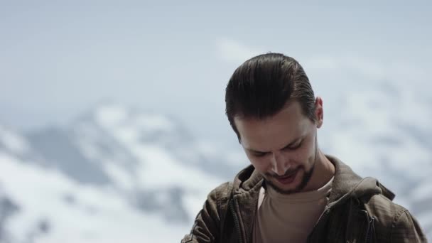 Young bebaarde man op de bergtop met schilderachtig uitzicht zet op zonnebrillen — Stockvideo