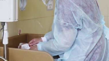 Tıbbi bornoz hemşire, bebeği yeni doğan bebek hamile hastanede maske. Bebek. Çocuk. Yenidoğan