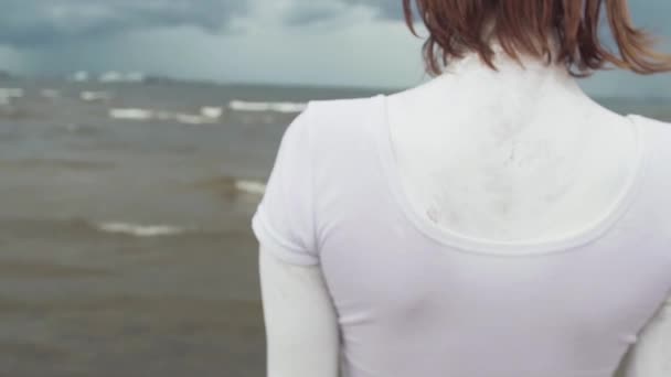 Vissza a művészi lány borított fehér festékkel állt a tenger partján — Stock videók