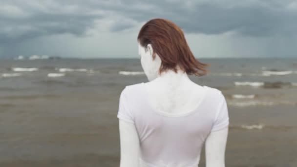 Beyaz boya daimi deniz kıyısında sanatsal kadın arkası kapalı — Stok video