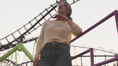 Çekici kız bardaklarda parlak güneş patlaması lunapark treni yakınında duran