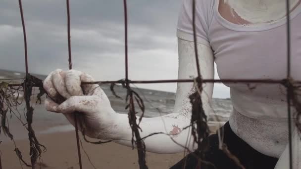 Die mit weißer Farbe überzogene Hand der Aktionskünstlerin hält Metallstangen — Stockvideo
