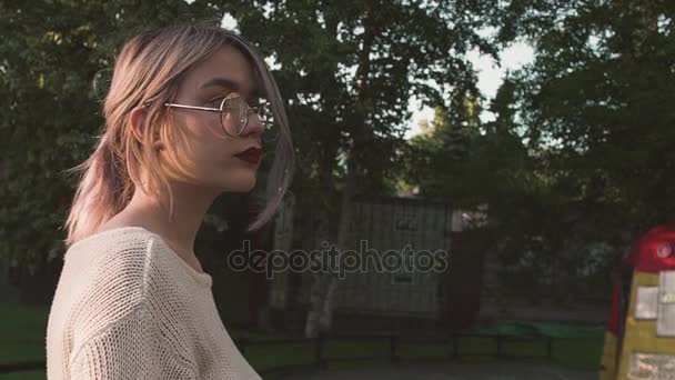 Krásná mladá dívka, rozhlédl se kolem sebe v amusment parku — Stock video