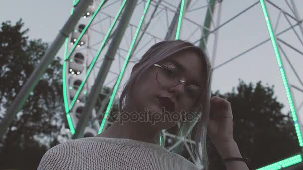 Sexy chica joven en gafas posando bajo la rueda del hurón con luces intermitentes — Vídeo de stock