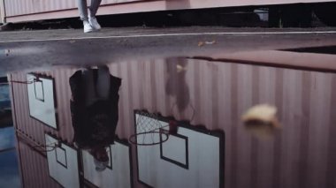 Su birikintisi yansımasıdır çekici kız yürüyor basketbol ağlarının duvar tarafından