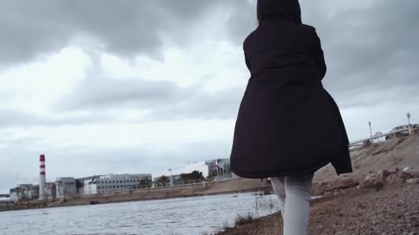 Persona en parket de invierno caminando por la orilla del agua en el área urbana de la ciudad — Vídeos de Stock