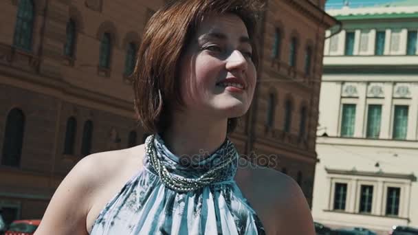 Веселая вокалистка выступает в старом городе в летнем платье — стоковое видео
