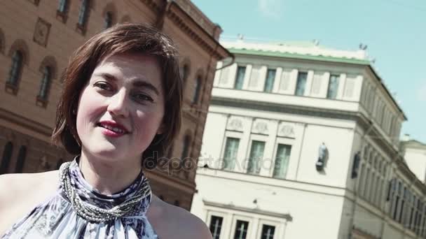 Радостная вокалистка выступает в старом городе в летнем платье — стоковое видео