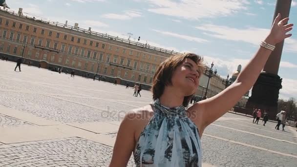 Радостная женщина в летнем платье поет на Дворцовой площади в Санкт-Петербурге — стоковое видео