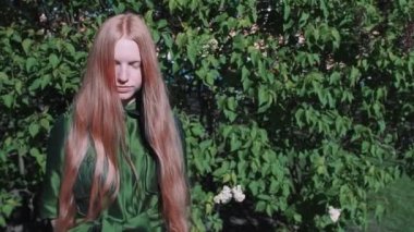 Uzun saçlı Kızıl saçlı güzel kız Park bush ayakta