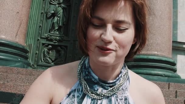 Young woman in summer dress smiling in front of old orthodoxal church door — Stock Video