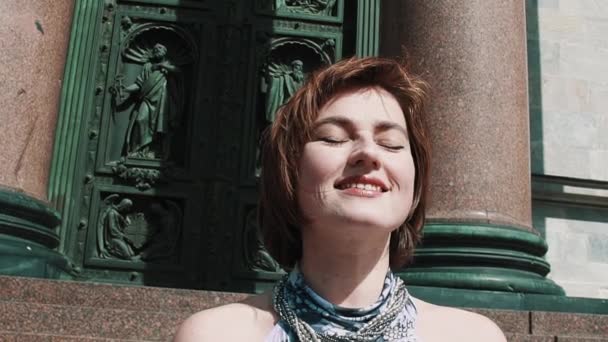 Veselá dívka v letních šatech s úsměvem před staré dveře kostela orthodoxal — Stock video