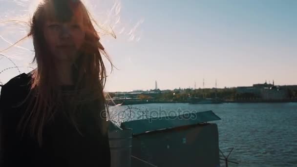 Lovely young woman in black dress on rooftop with scenic city river view — Stock Video