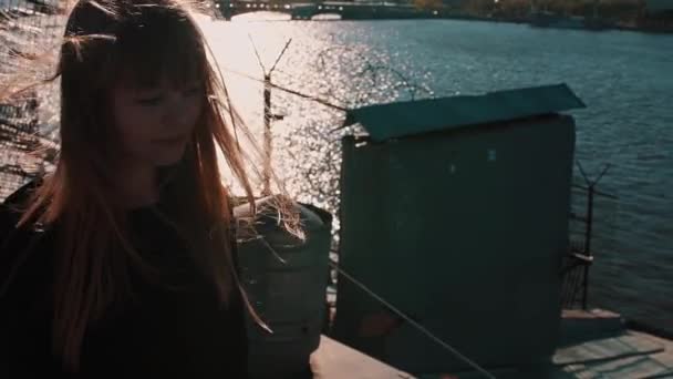 Aranyos fiatal nő, fekete ruhás, a tetőtéri festői város kilátással a folyóra — Stock videók