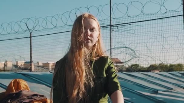 Hosszúszőrű gyömbér csinos lány ül a Tetőfedő barb Wire zöld ruhában — Stock videók