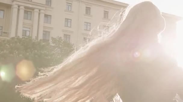 Молода красива дівчина-лисиця в зеленому платті, що крутиться на міській площі — стокове відео