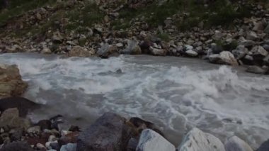 Kayalık yeşil ağaçlar, karlı zirveleri kaplı dağ akışında sahne görünümünü